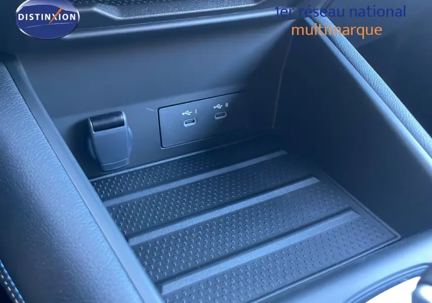 Gros plan sur la console centrale noire avec ports USB-C doubles et prise 12V du Renault Symbioz bleu Iron Metal.