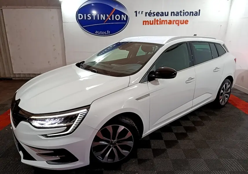 Renault Mégane Techno TCe 140 blanc vue 3/4 avant droit, feux LED allumés et jantes alliage distinctives.