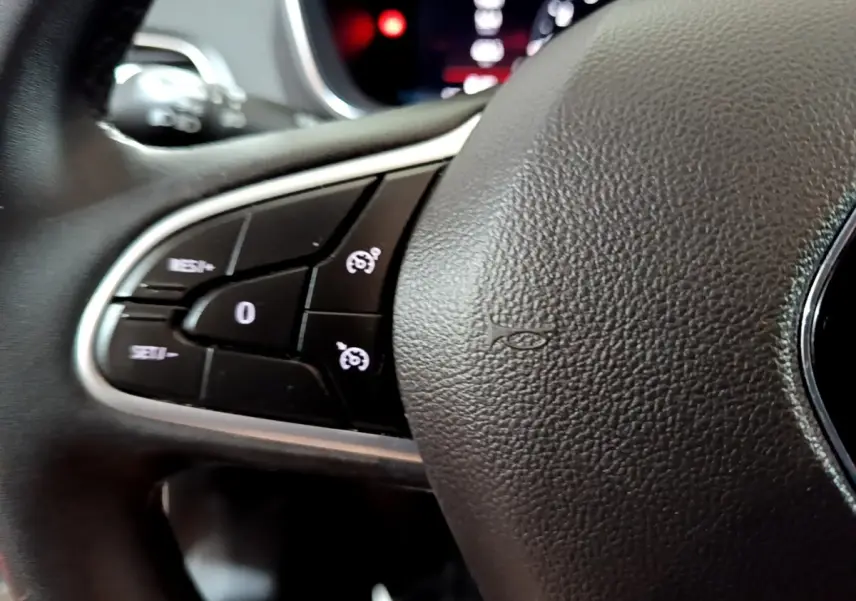 Gros plan sur les commandes du volant noir de la Renault Mégane Techno TCe 140 EDC 2023.