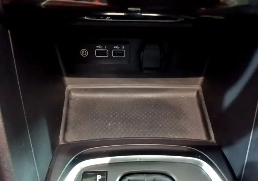 Gros plan sur la console centrale noire de la Renault Mégane Techno 2023 avec ports USB et prise 12V visibles.