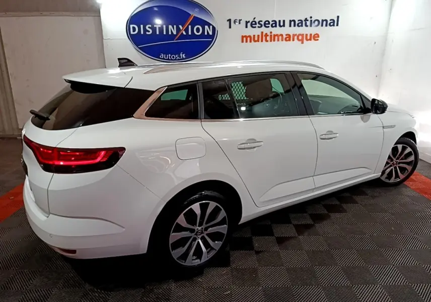 Renault Mégane Techno TCe 140 blanc vue 3/4 arrière droit, feux LED allumés et jantes alliage visibles.