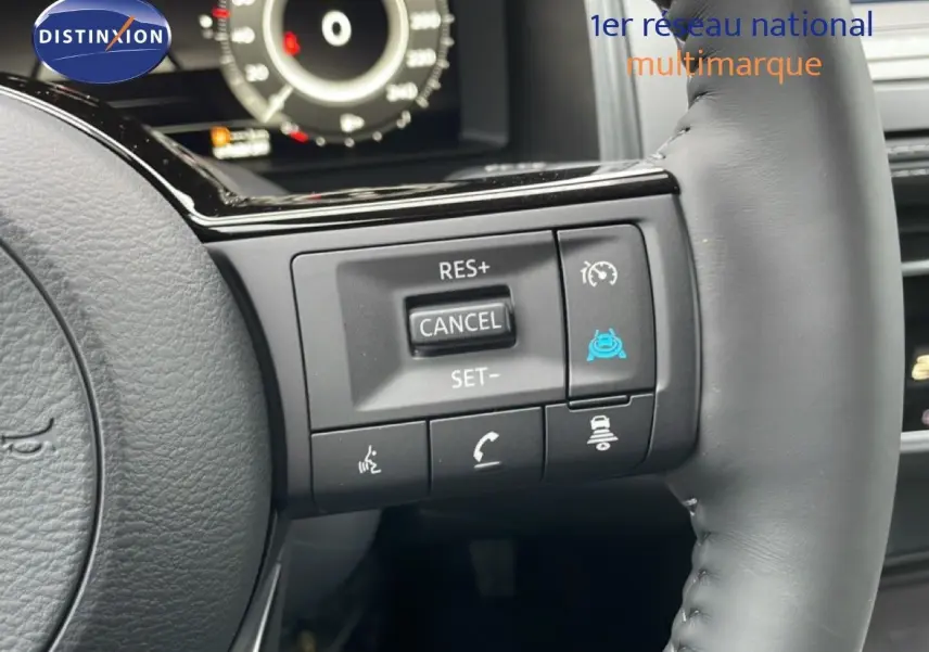 Gros plan sur les commandes au volant côté droit du Nissan Qashqai noir perle métal 2025, affichage numérique en arrière-plan.