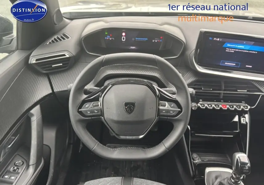 Vue intérieure du poste de conduite du Peugeot 2008 gris sellenium, volant multifonction et écran tactile visible.