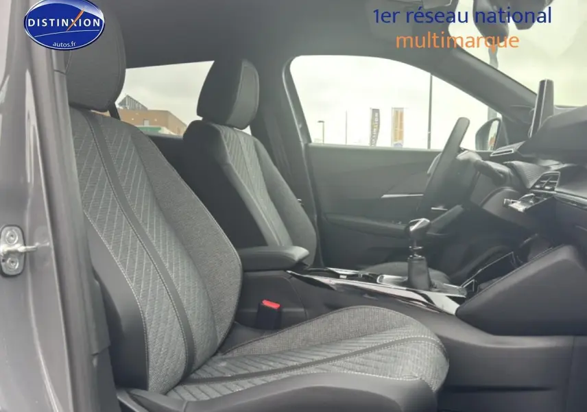 Vue intérieure côté gauche du Peugeot 2008 1.2 100 Allure gris sélénite, mettant en valeur les sièges en tissu embossé.