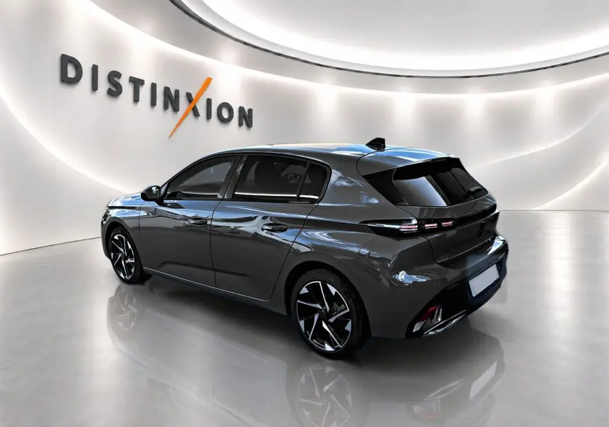 Peugeot 308 gris selenium vue 3/4 arrière droit, jantes alliage noires et feux arrière LED distinctifs.