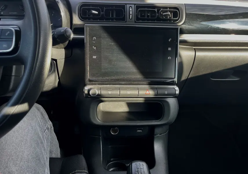 Vue intérieure centrée sur la console centrale et l'écran tactile de la Citroën C3 blanche de 2019 avec boîte manuelle.