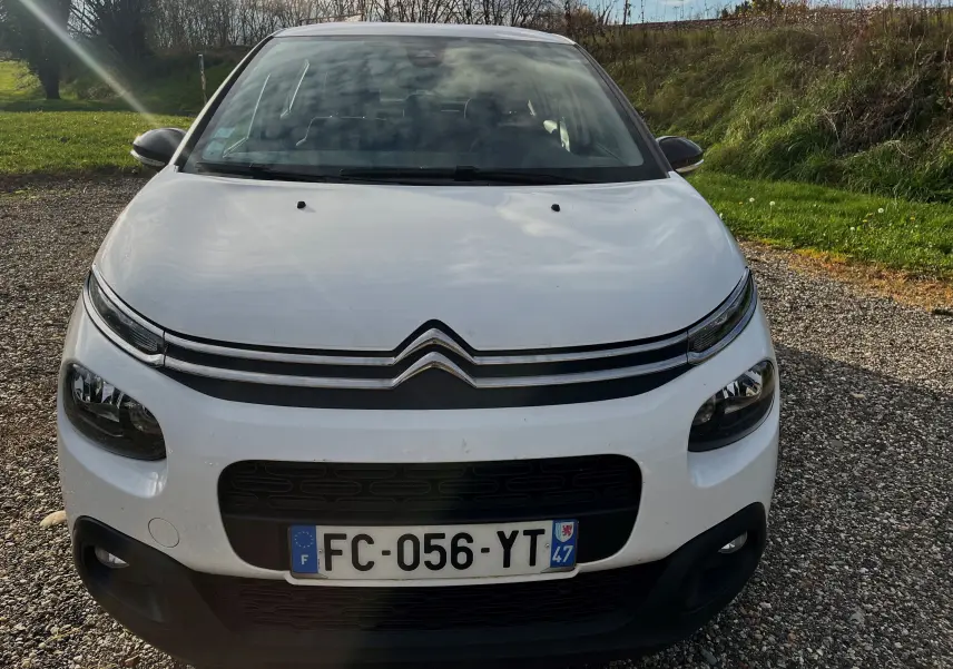 Vue frontale d'une Citroën C3 blanche de 2019 avec calandre noire et plaque d'immatriculation française visible.