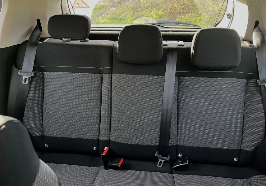 Vue intérieure arrière des sièges noirs et gris de la Citroën C3 blanche 2019, avec ceintures de sécurité visibles.