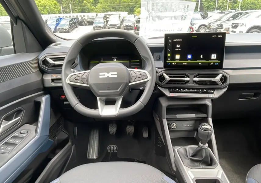 Vue intérieure avant du tableau de bord du Dacia Bigster 2025 avec volant cuir et écran tactile central.