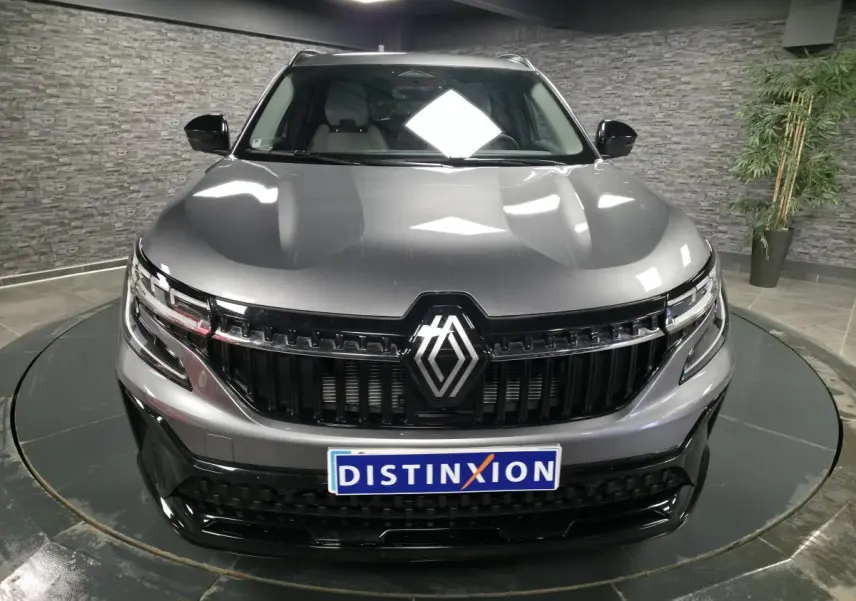 Vue frontale d'un Renault Espace gris avec calandre noire brillante et phares LED Matrix Vision allumés.