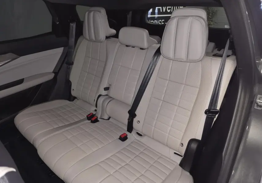 Banquette arrière beige clair en textile refined avec surpiqûres marron visible côté droit du Renault Espace gris 2025.