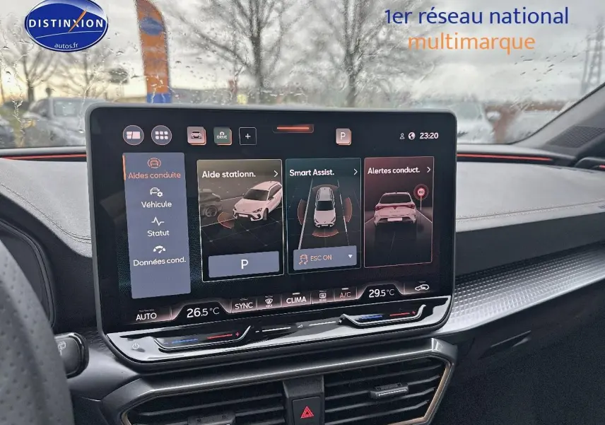 Vue intérieure du tableau de bord de la CUPRA LEON ST 2025 avec écran tactile multifonction sous pluie.