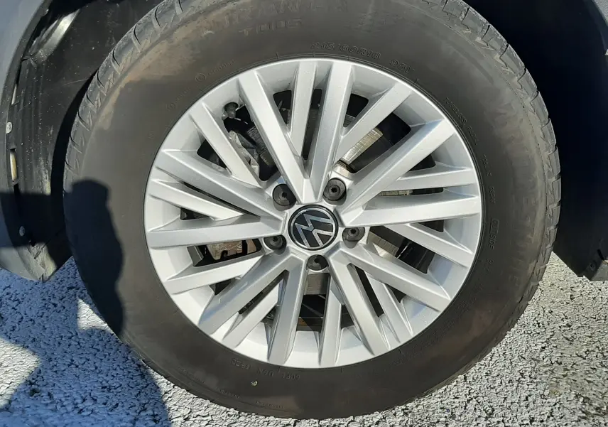 Gros plan sur la roue avant droite d’un Volkswagen T-Roc bleu 2022 avec jante alliage argentée à multiples branches.