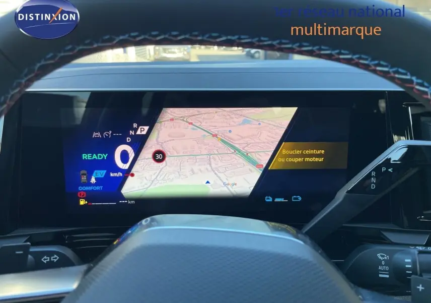 Vue intérieure du tableau de bord numérique du Renault Austral E-Tech hybride, avec affichage de navigation et commandes au volant.