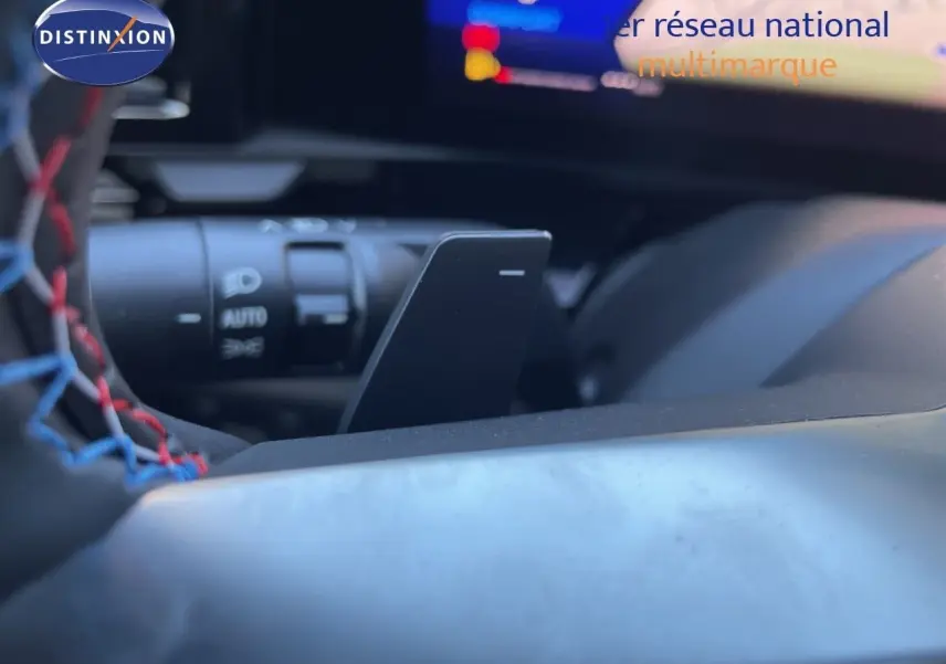 Détail du volant noir avec surpiqûres tricolores et palette de changement de vitesse dans un Renault Austral 2026.