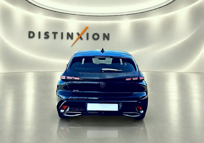 Vue arrière d'une Peugeot 308 noire 2025, avec feux arrière LED et logo distinctif au centre du hayon.