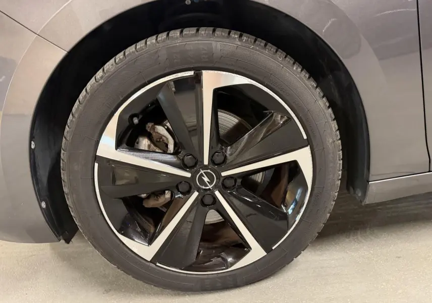 Gros plan sur la jante alliage 17 pouces diamantée noire et argentée côté gauche d’une Opel Astra gris foncé.