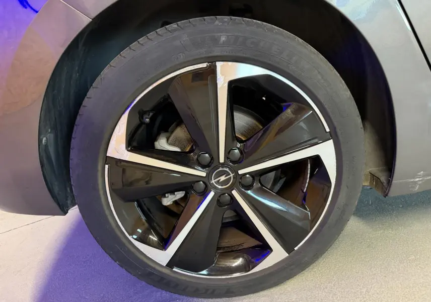 Gros plan sur la jante alliage 17 pouces diamantée noire et argentée de l'Opel Astra gris foncé 2024.