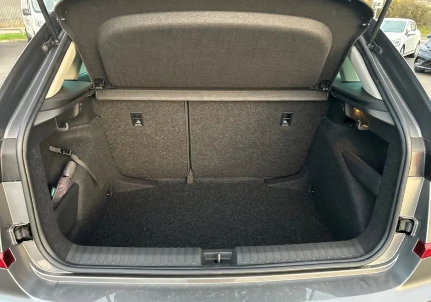 Coffre ouvert gris clair du Skoda Kamiq 2025, vue arrière montrant l'espace de chargement vide et la tablette de coffre.