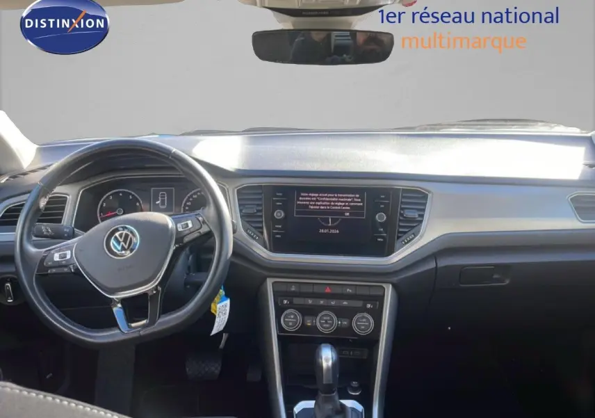 Vue intérieure avant du Volkswagen T-Roc bleu Ravenna Metal 2021, mettant en valeur le tableau de bord et le volant multifonction.