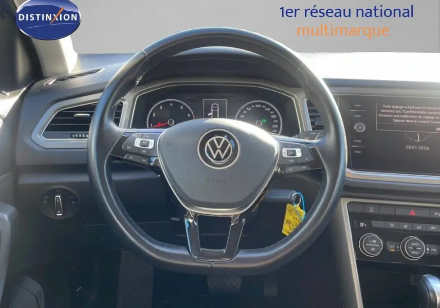 Vue intérieure centrée sur le volant noir du Volkswagen T-Roc 1.5 TSI 2021 avec tableau de bord et écran multimédia.