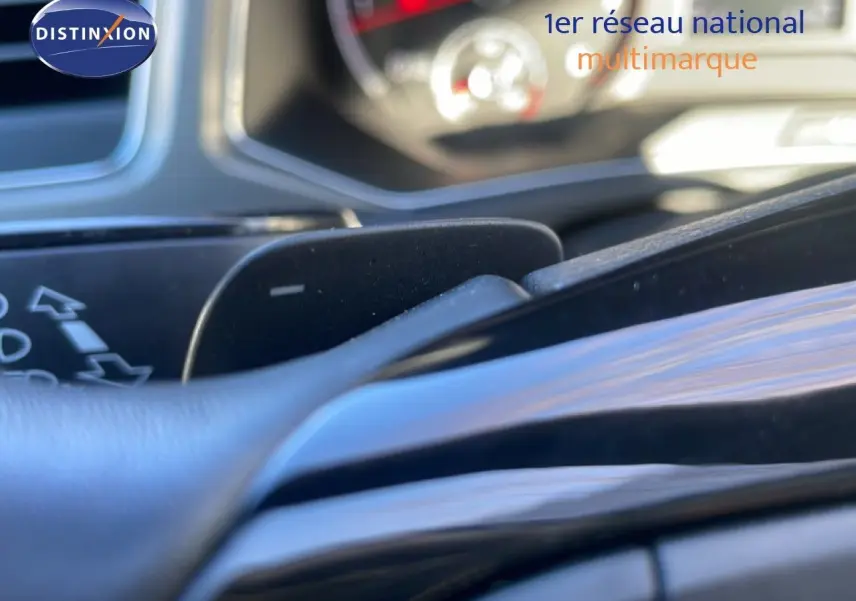 Gros plan sur la palette de changement de vitesse au volant du Volkswagen T-Roc bleu Ravenna, intérieur noir.