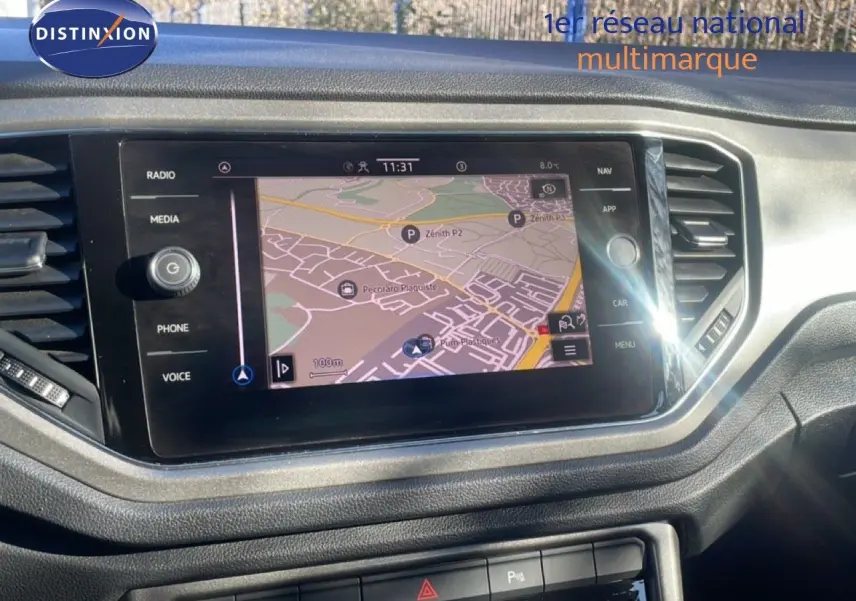 Écran tactile central avec navigation GPS dans l’habitacle d’un Volkswagen T-Roc bleu Ravenna, vue de face.