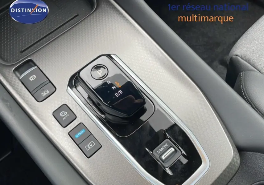 Gros plan sur la console centrale du Nissan Qashqai gris squale métal, avec sélecteur de boîte automatique et boutons de mode de conduite.