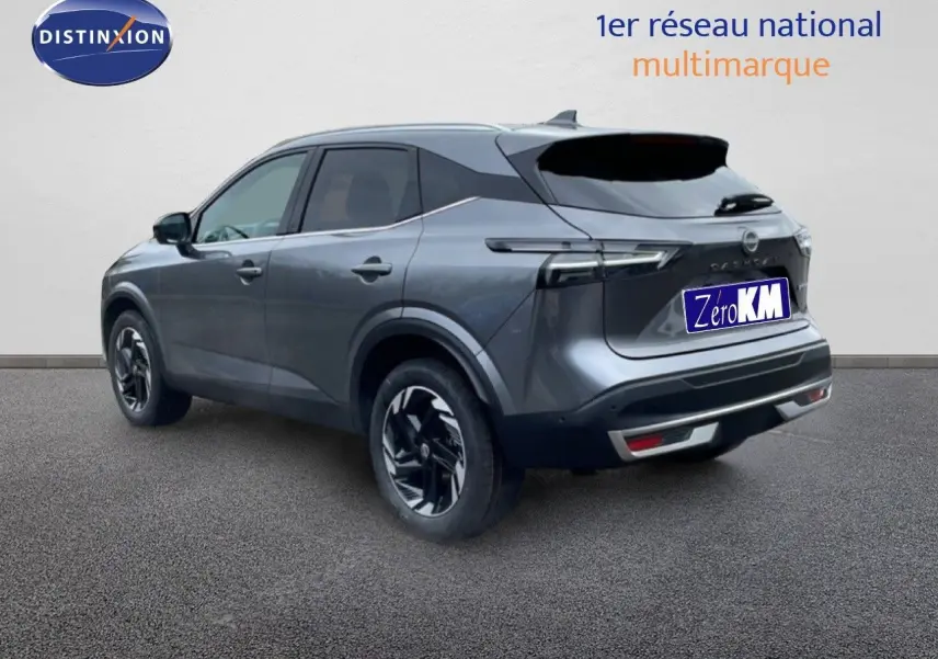 Vue 3/4 arrière d'un Nissan Qashqai 2025 gris squale métal avec jantes noires et feux arrière LED distinctifs.