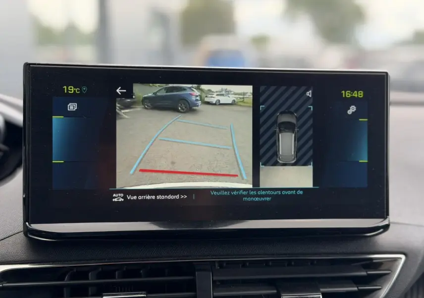 Écran tactile intérieur montrant la caméra de recul et l'aide au stationnement du Peugeot 3008 noir Perla, vue arrière.