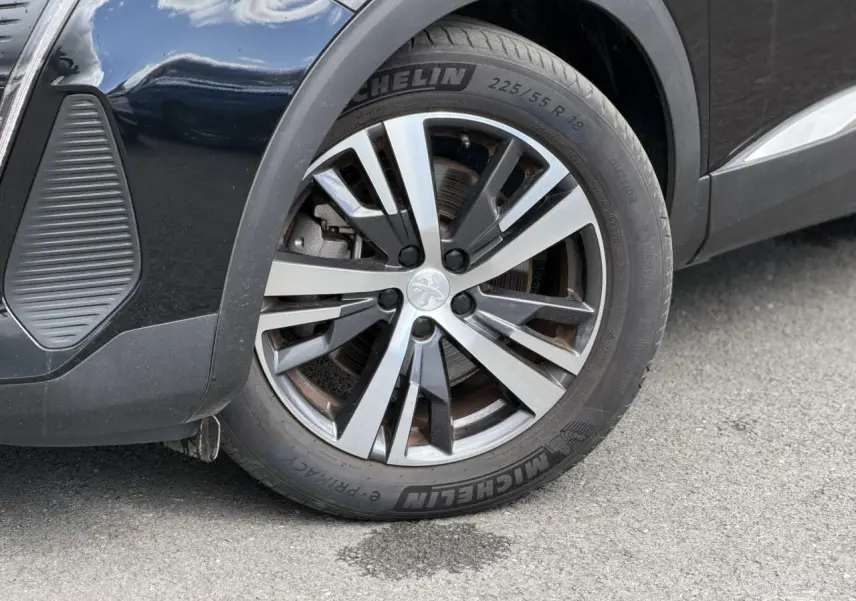 Gros plan sur la roue avant gauche du Peugeot 3008 noir Perla avec jante alliage bi-ton 18 pouces Detroit.