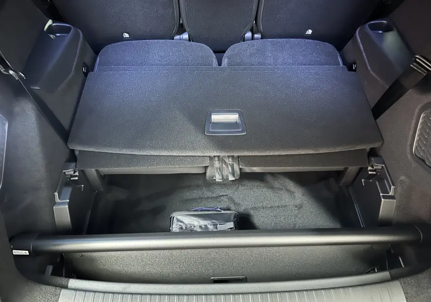 Coffre ouvert du Peugeot 5008 gris Artense, montrant le rangement sous plancher et la banquette arrière rabattue.