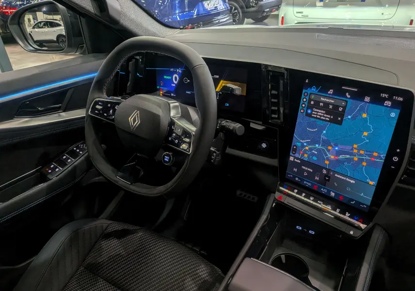Intérieur du Renault Austral 2025 full hybride, vue côté conducteur sur le tableau de bord numérique et l'écran tactile central.