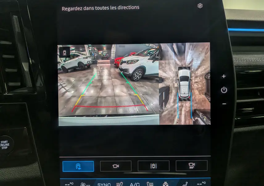 Écran multimédia montrant la caméra de recul et vue 360° du Renault Austral blanc nacré avec toit noir, intérieur moderne.