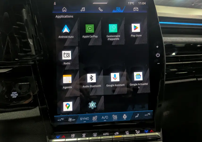 Écran tactile central du Renault Austral 2025 full hybride, affichant les applications connectées dans l'habitacle noir.