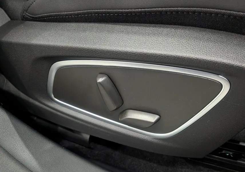 Gros plan sur les commandes de réglage électrique du siège côté gauche du Renault Austral blanc nacré 2025.