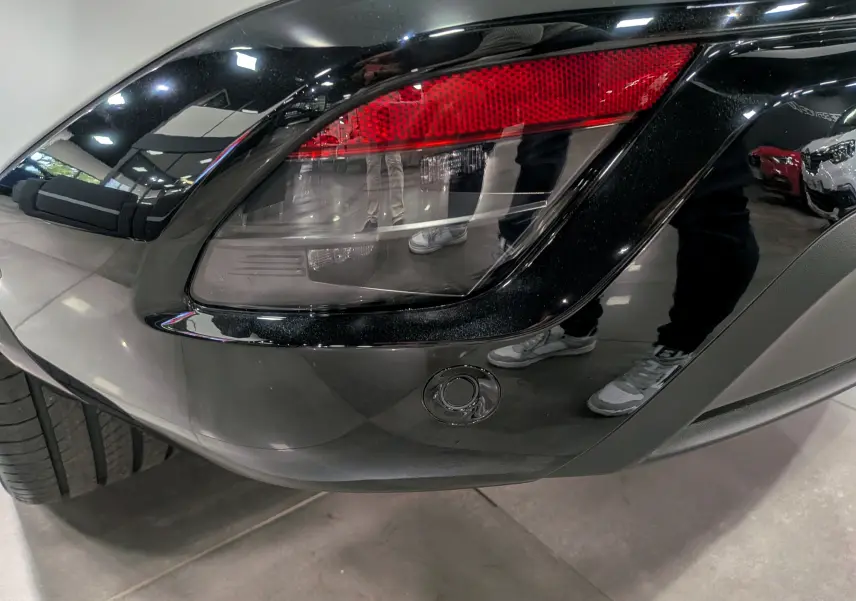 Gros plan sur le feu arrière droit noir brillant du Renault Austral 2025 blanc nacré satin avec toit noir.