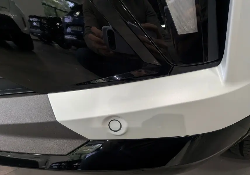 Détail du pare-chocs arrière blanc nacré satin avec capteur de stationnement sur Renault Austral 2025.