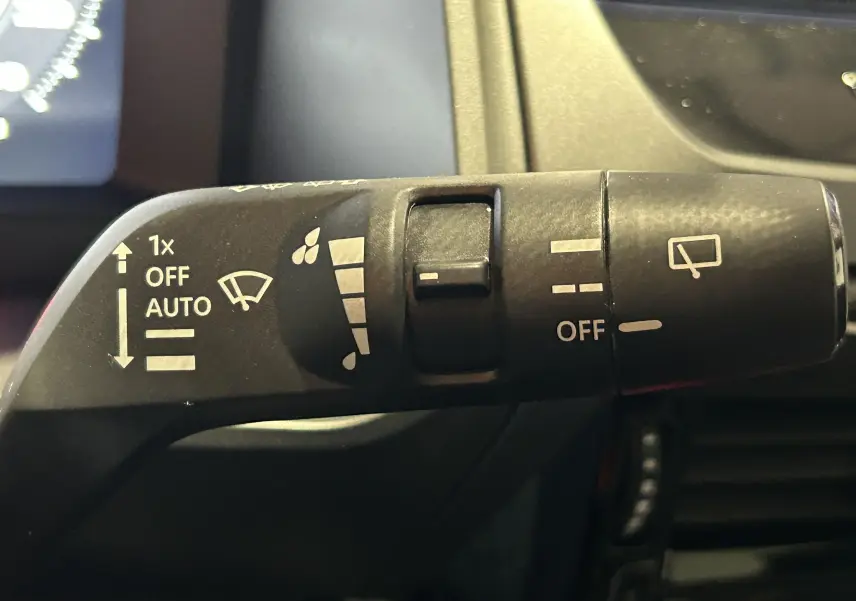 Gros plan sur la commande d’essuie-glace du Nissan Qashqai gris céramique, avec réglages automatiques visibles.