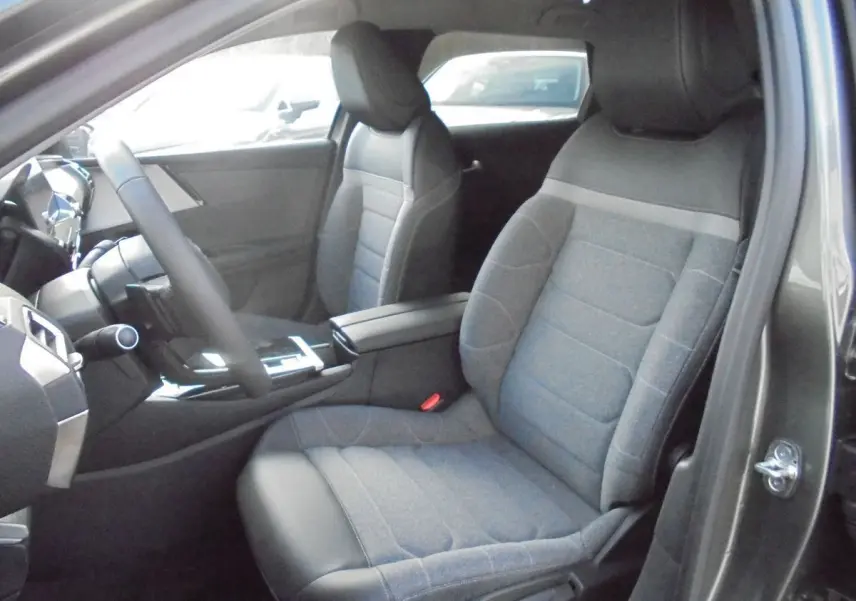 Vue intérieure côté conducteur du Citroën C5 X 2022 gris platinum, montrant les sièges tissu et cuir et la console centrale.