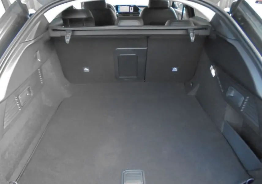 Coffre ouvert d’une Citroën C5 X gris platinum 2022, vue arrière montrant l’espace de chargement et la tablette cache-bagages.