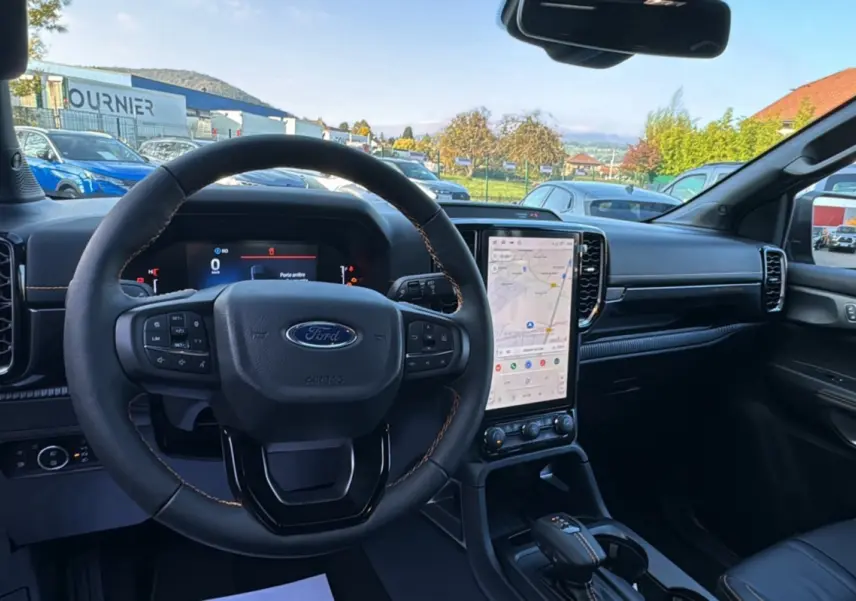 Intérieur du Ford Ranger PHEV 281 Wildtrak gris iconic, vue centrée sur le volant cuir et l'écran tactile vertical.