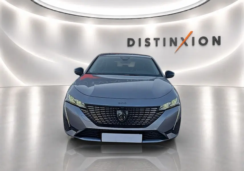 Peugeot 308 SW 2025 gris artense vue de face, avec calandre large et phares LED fins dans un studio lumineux.