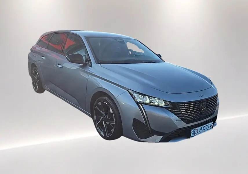 Peugeot 308 SW gris Artense vue 3/4 avant droit avec calandre noire et jantes alliage distinctives.