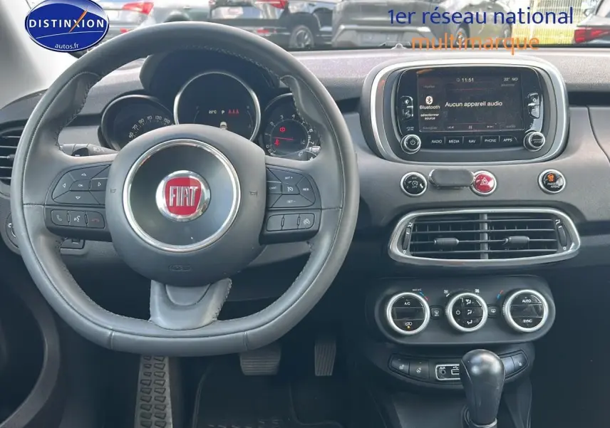 Vue centrée sur le volant cuir multifonction et tableau de bord du Fiat 500X 1.4 rouge de 2016.