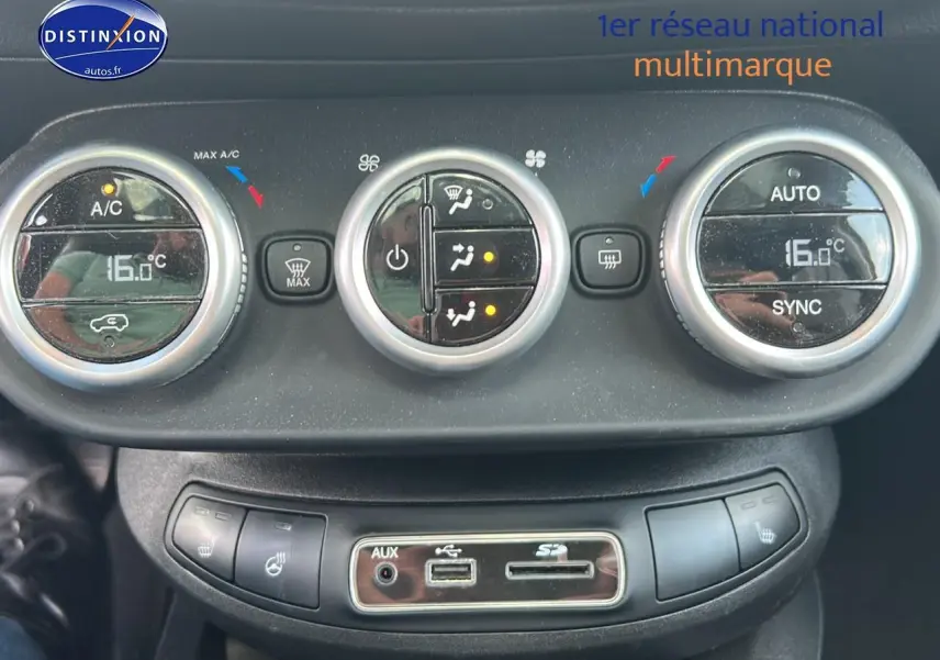 Gros plan sur la commande de climatisation automatique bi-zone avec affichage digital à bord d'une Fiat 500X rouge.