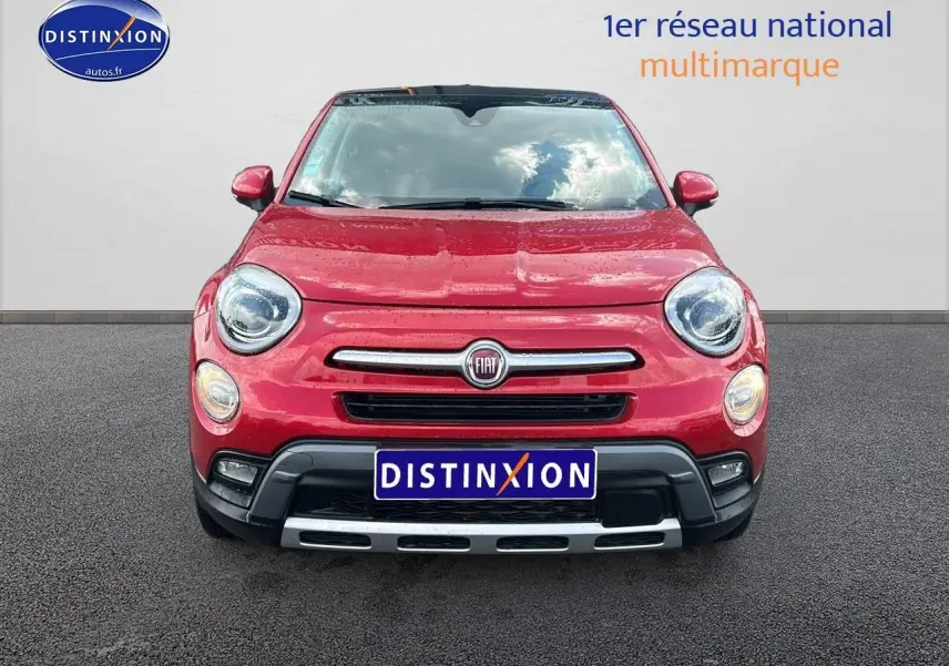 Vue frontale d'une FIAT 500X rouge 2016 avec bouclier noir et calandre chromée sur sol goudronné.