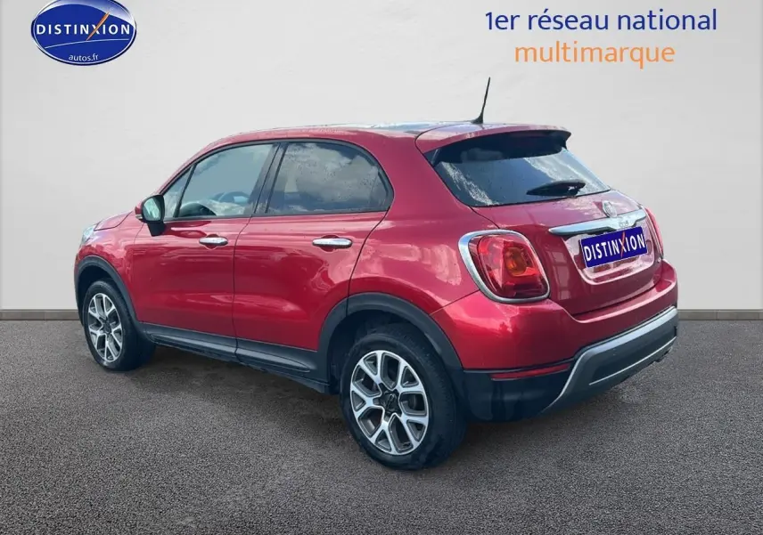 Vue 3/4 arrière droite d'un FIAT 500X rouge avec jantes alu et vitres arrière surteintées sur fond neutre.