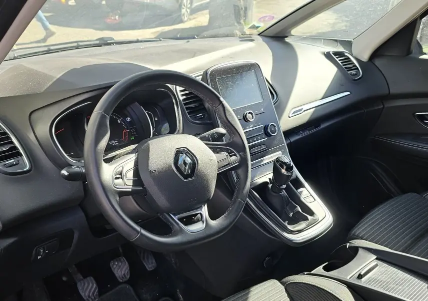 Vue intérieure côté conducteur du Renault Scénic 2020 avec tableau de bord noir et console centrale tactile.