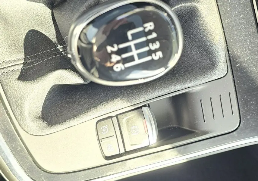 Gros plan sur le levier de vitesse manuel noir du Renault Scenic 1.3 TCE 115CH Business, intérieur tissu gris.